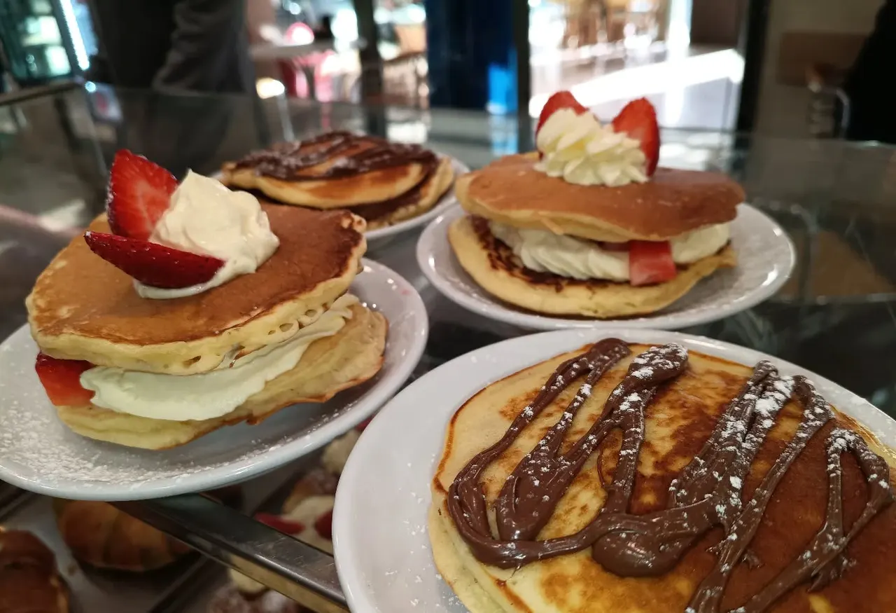 Pancake con fragole e panna, cioccolato e zucchero a velo, pronti al passaggio
